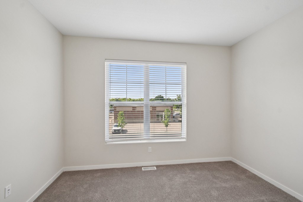 A room with a window and a view of a building outside at Ironwood Townhomes in Medina, Minnesota.