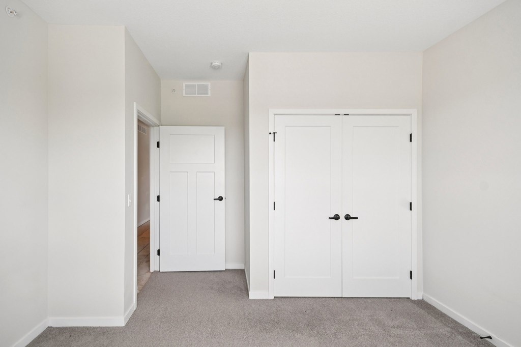 A white door is on the left and a white double door is on the right at Ironwood Townhomes in Medina, Minnesota.