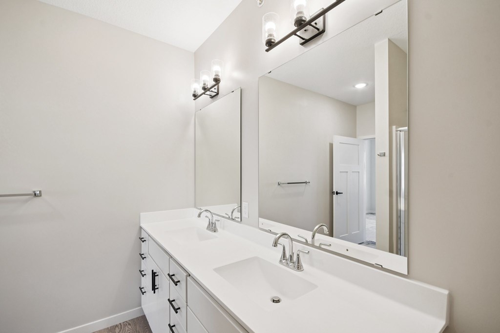 Primary bathroom vanity two sinks and mirror at Ironwood Townhomes in Medina, Minnesota.