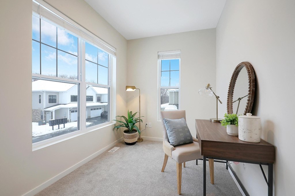 A room with a chair, table, and a mirror.