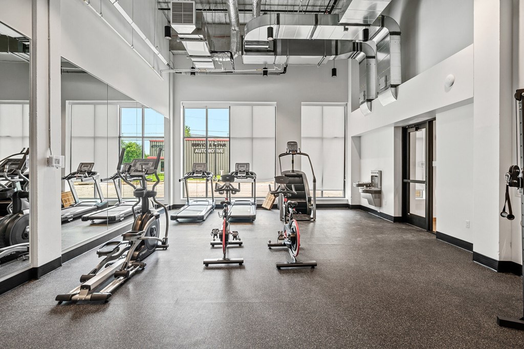 a fitness room with treadmills and other exercise equipment