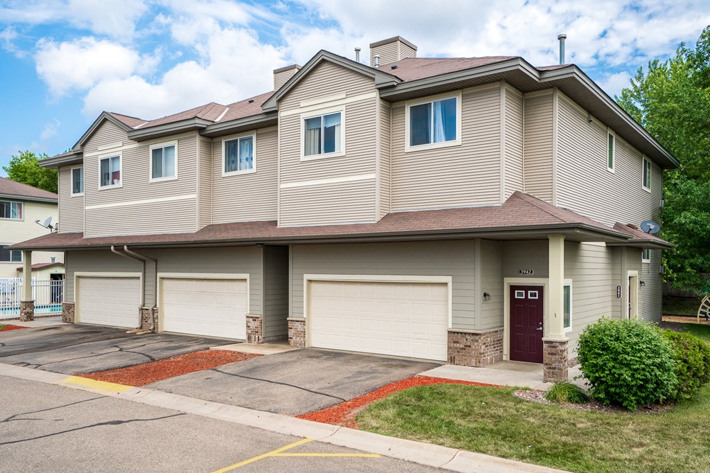 a tan and brown house with two garage doors