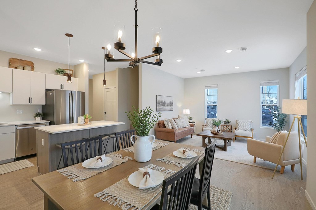 A modern dining room with a wooden table set for two.