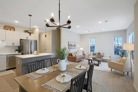 A modern dining room with a wooden table set for two.