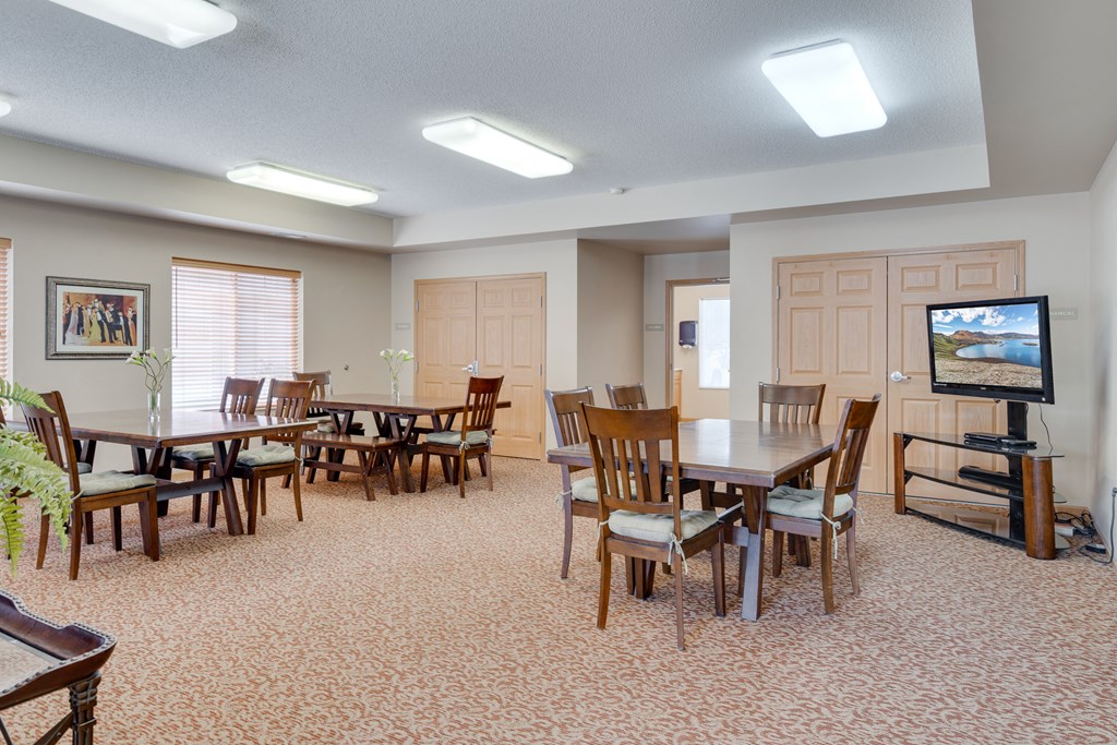 a dining room with tables and chairs and a television