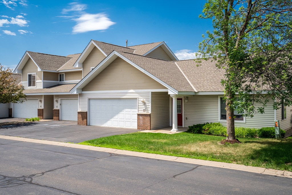 a house with two garage doors and a street in front of it