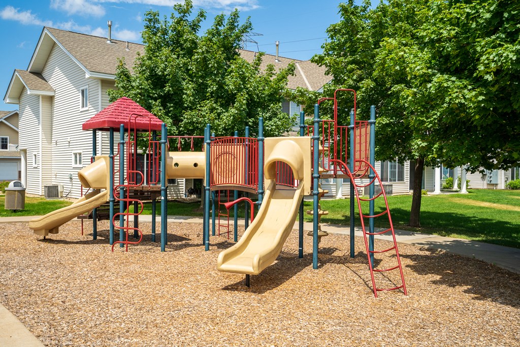 a playground with two slides and a swing set