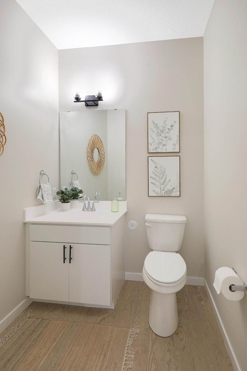 A white toilet sits next to a white sink in a small bathroom.