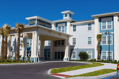 a large building with palm trees in front of it