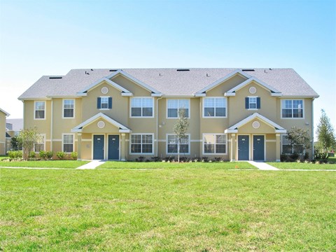 a large house with blue doors and a green lawn
