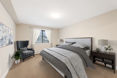 A bedroom with a large bed and a chair.