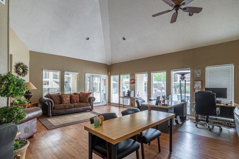 A living room with a brown couch and a wooden table.