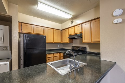 A kitchen with black appliances and wooden cabinets.