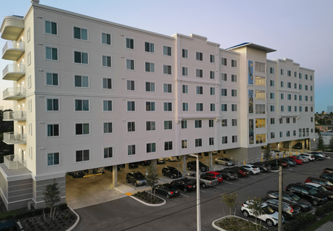 A large white building with a parking lot in front.