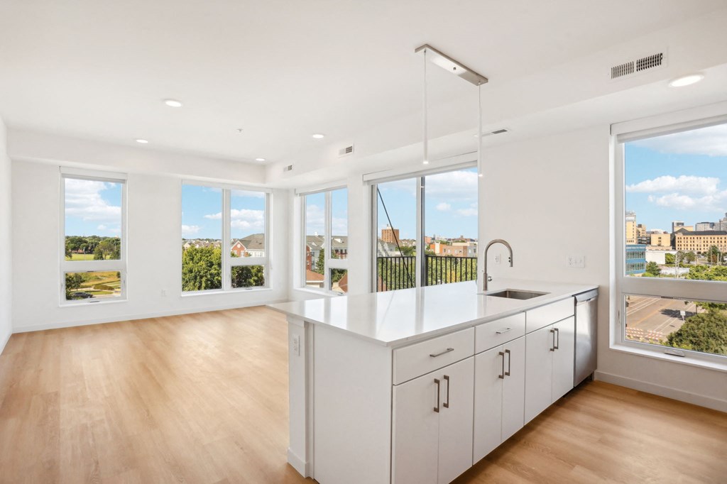 an open kitchen and living room with a large island and windows