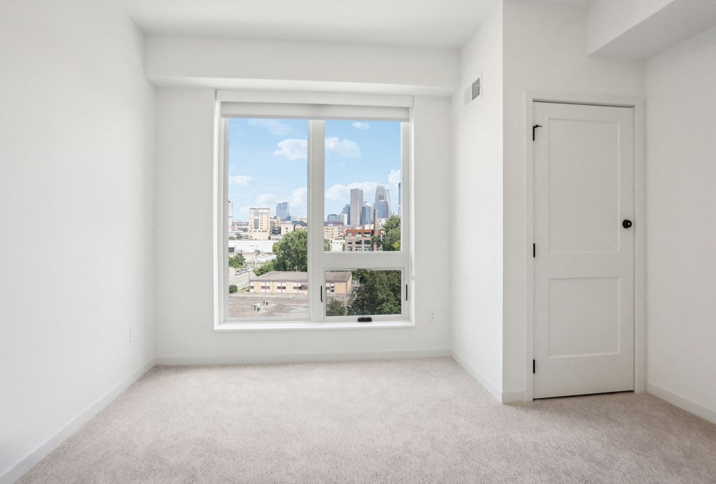 an empty room with a large window and a door