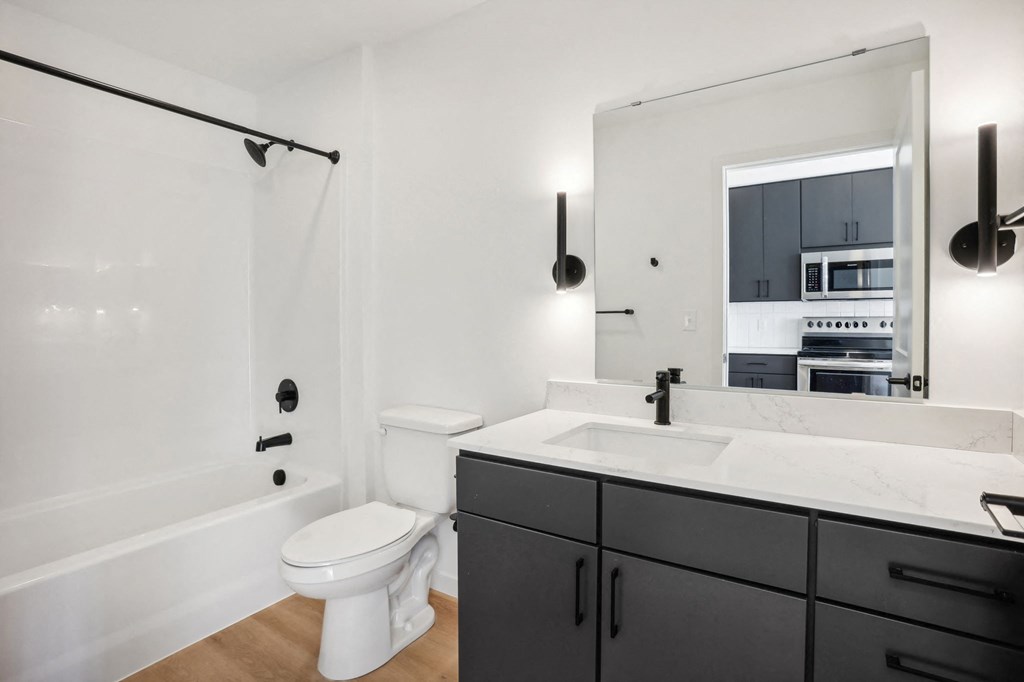 a black and white bathroom with a white toilet and a sink