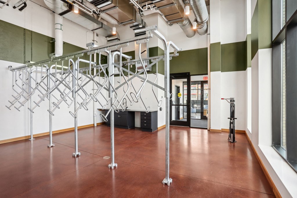 a large room with white and green walls and a brown floor with bike storage
