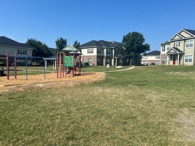 a playground in a park with houses in the background