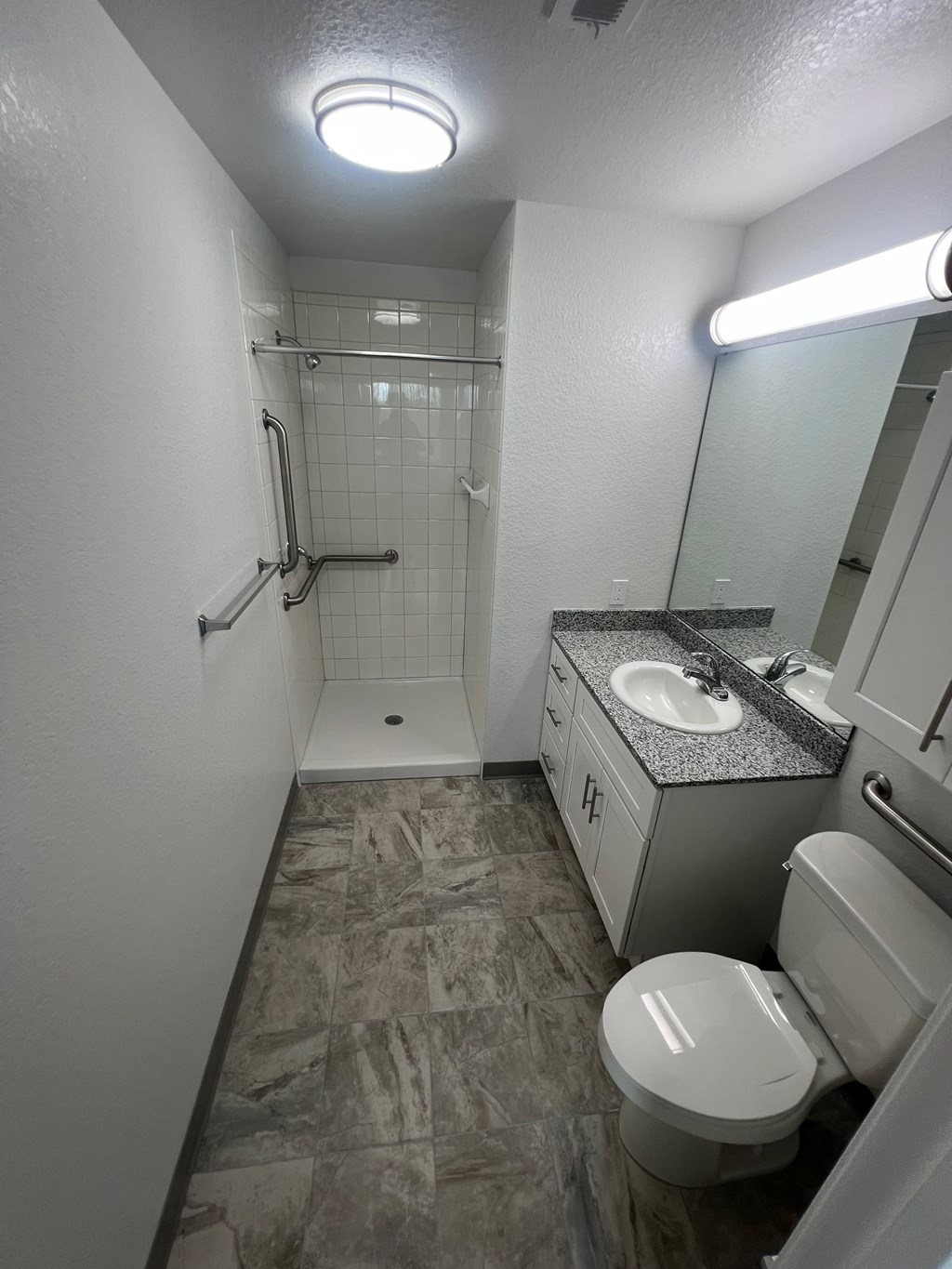A bathroom with a toilet, sink, and shower.
