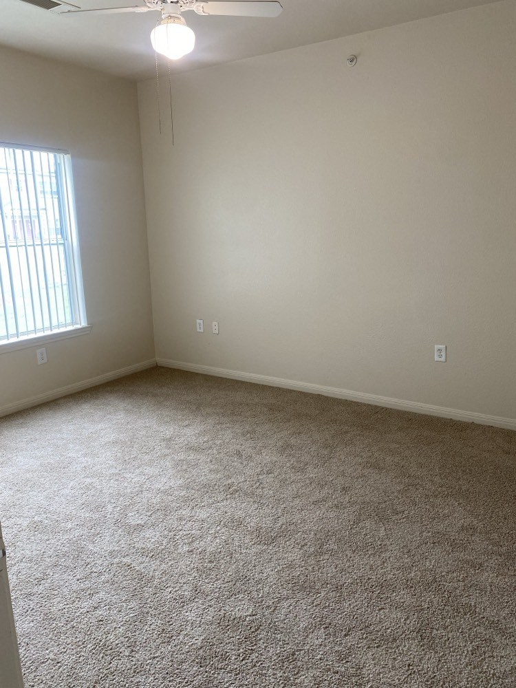 an empty room with a carpeted floor and a window