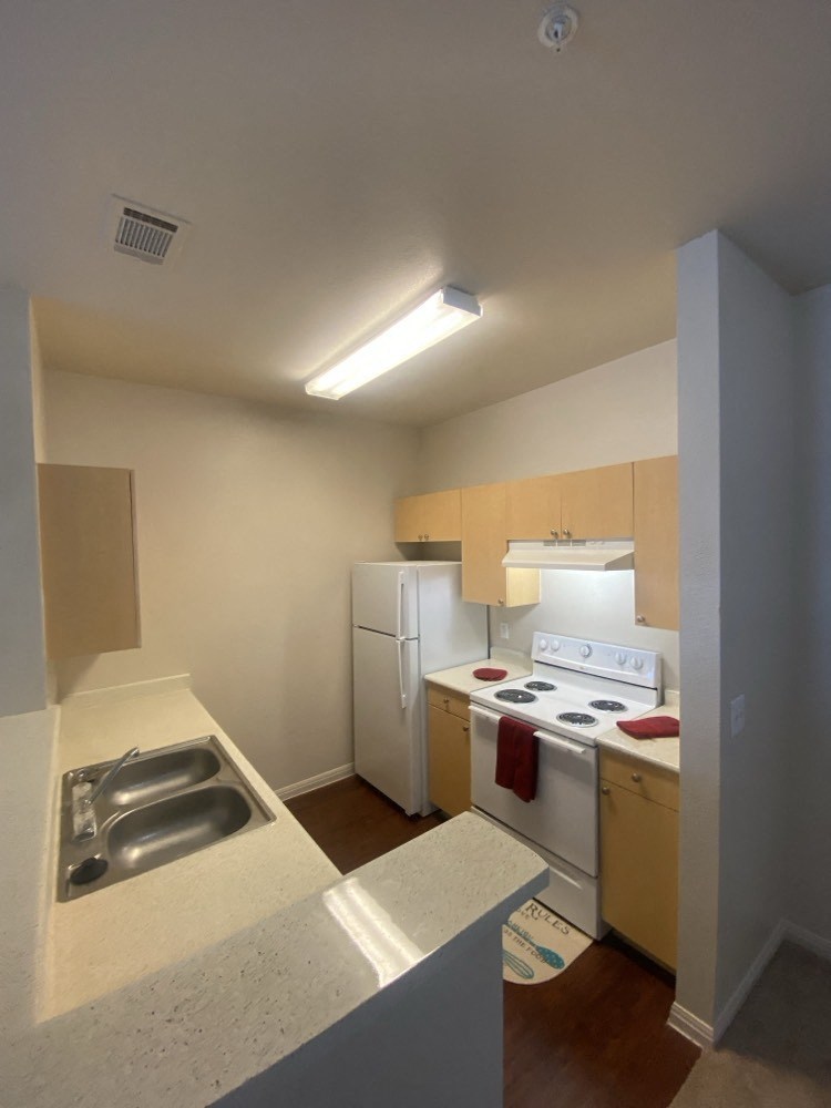 a kitchen with white appliances and a sink and a white refrigerator