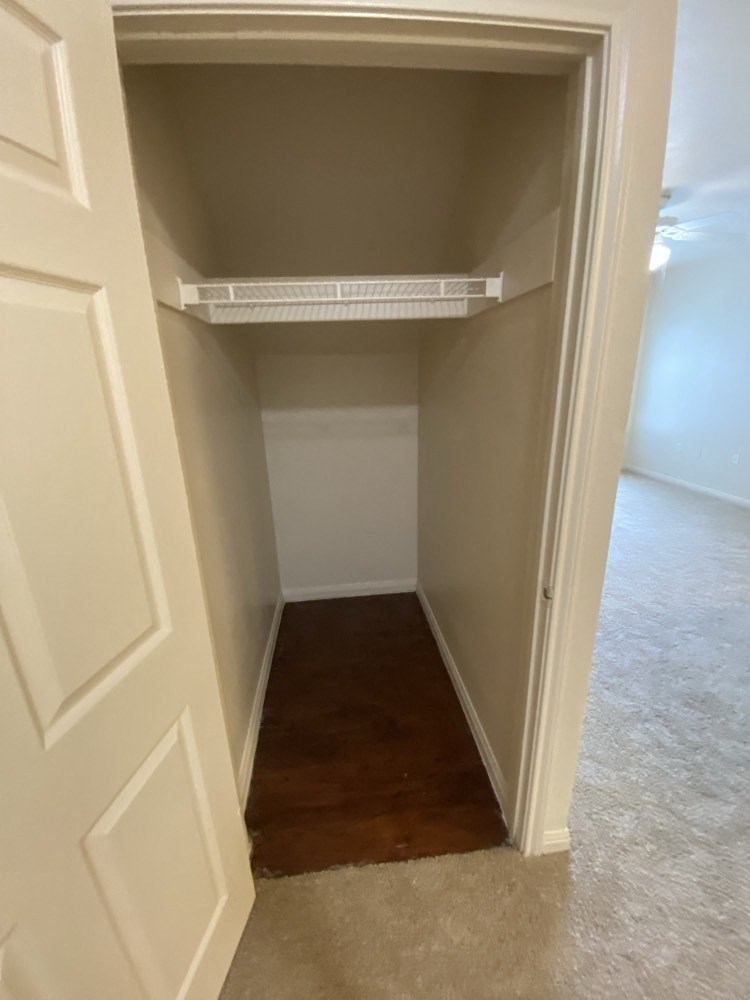 an empty closet with a wood floor and white doors