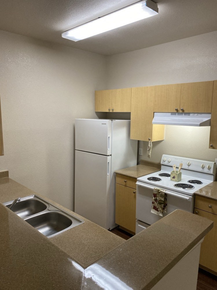 a kitchen with a stove refrigerator and a sink