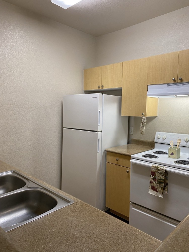 a kitchen with a stove refrigerator and a sink