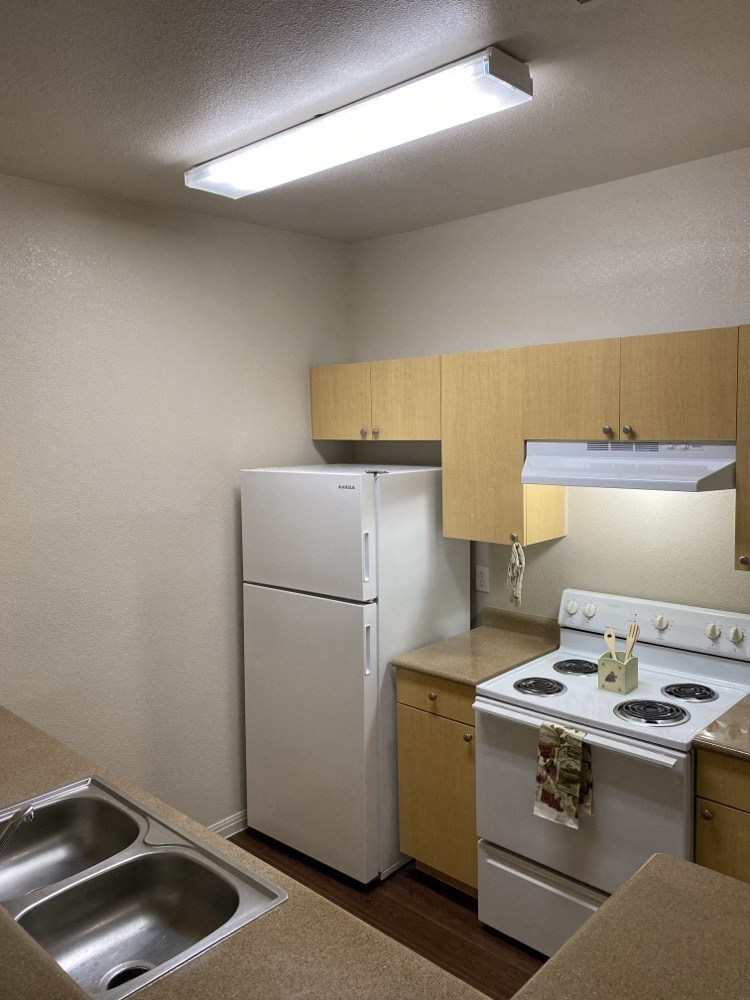 a kitchen with a stove refrigerator and a sink