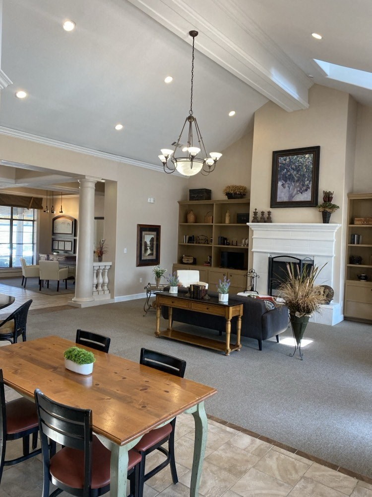 a living room with a fireplace and a table and chairs