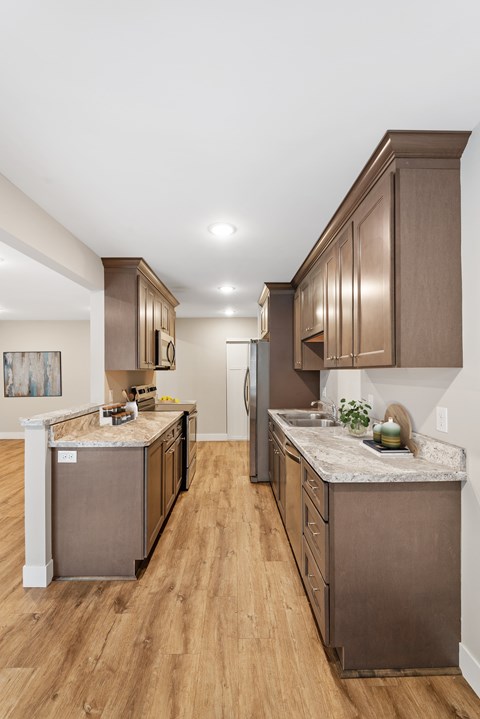 A kitchen with brown cabinets and a marble countertop.