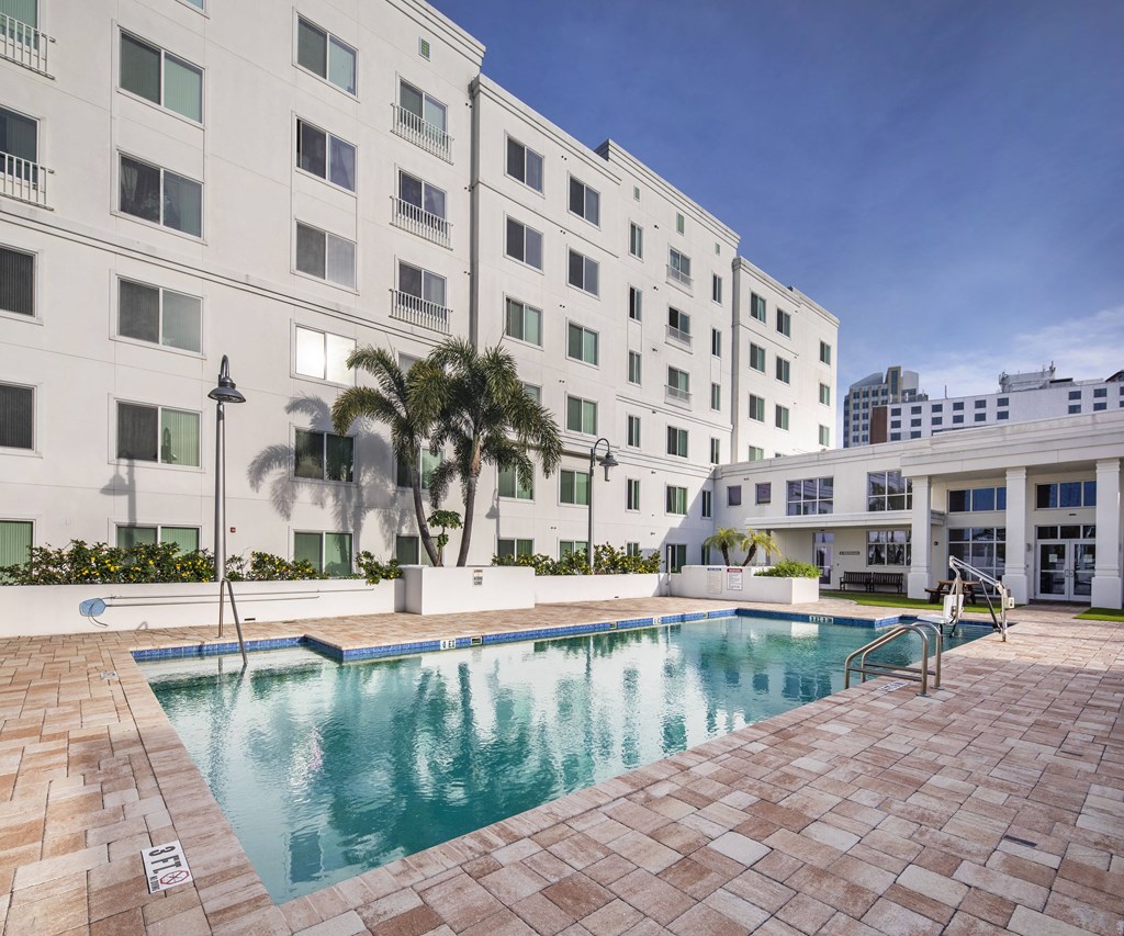 a swimming pool in front of a white building