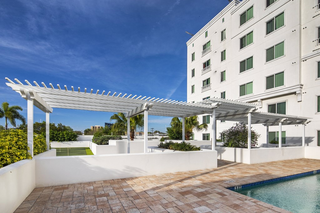a large white building with a pool and a white canopy