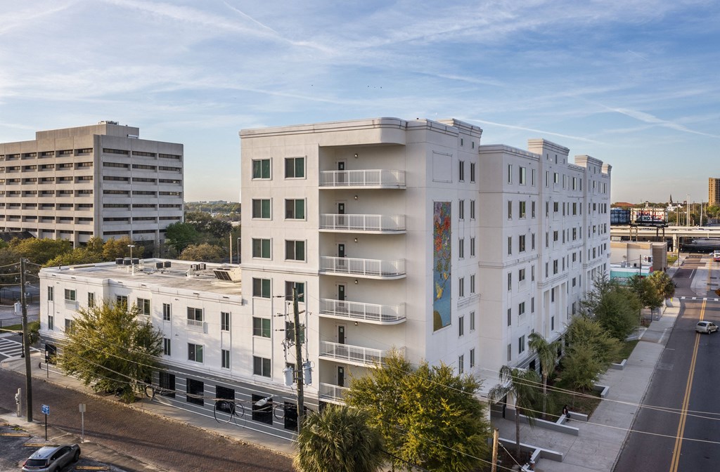 an aerial view of a white apartment building with balconies