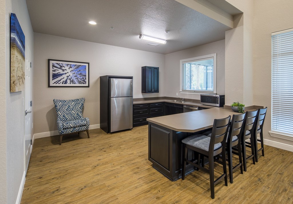 A kitchen with a dining table and chairs.