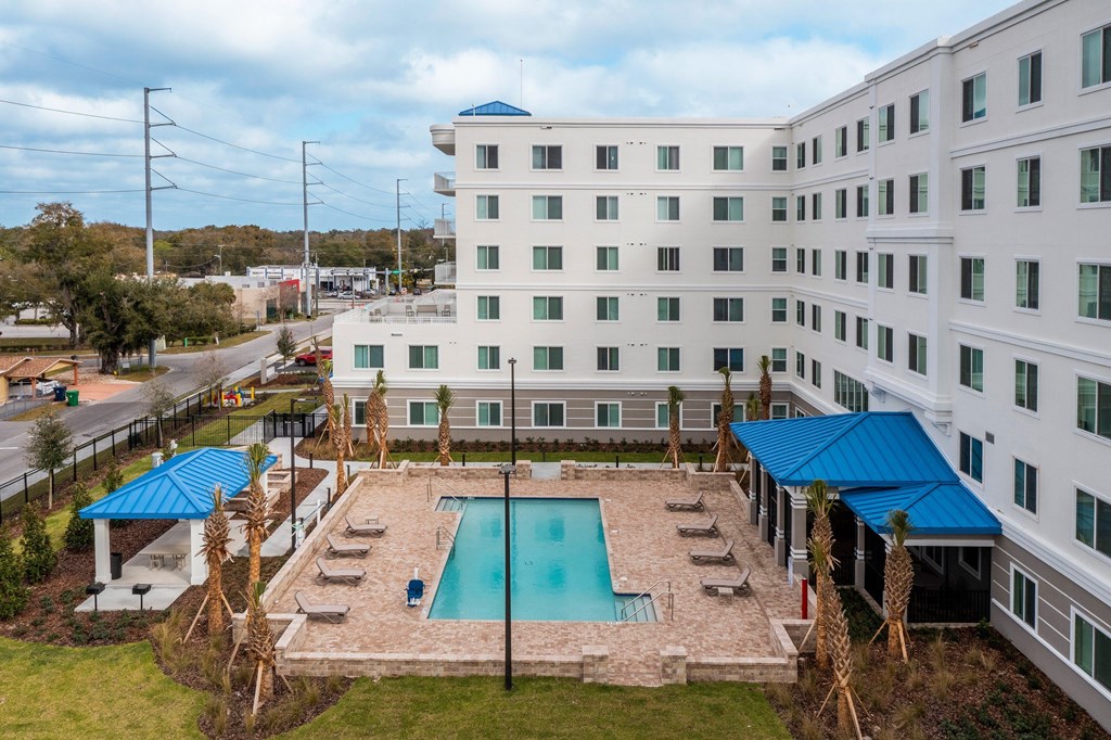 A large white building with a pool in front.