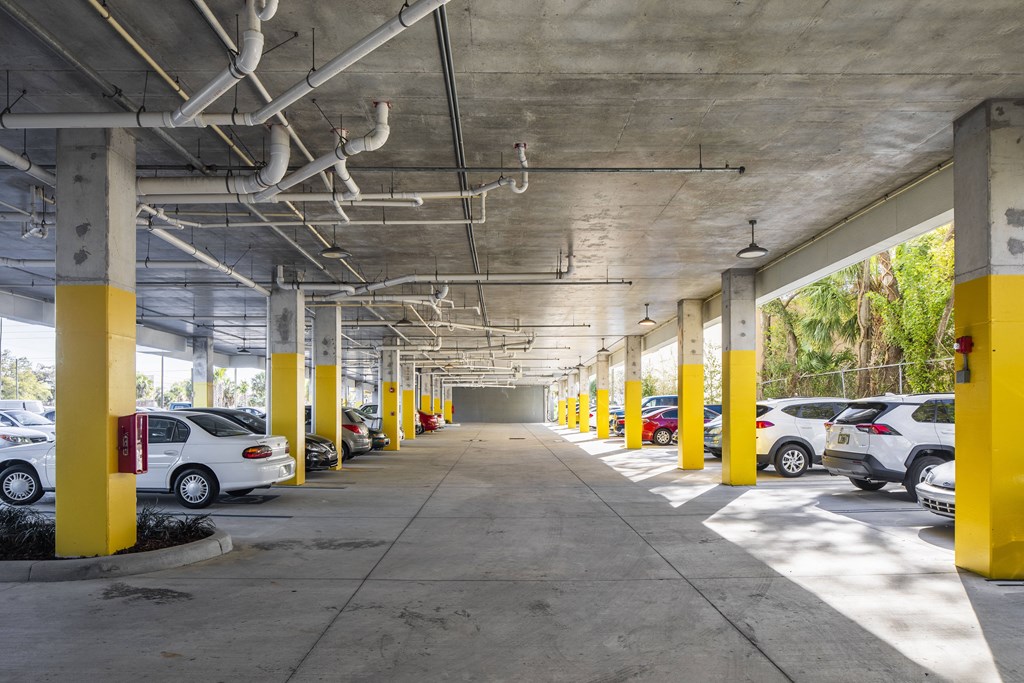 a parking garage with yellow pillars and cars parked
