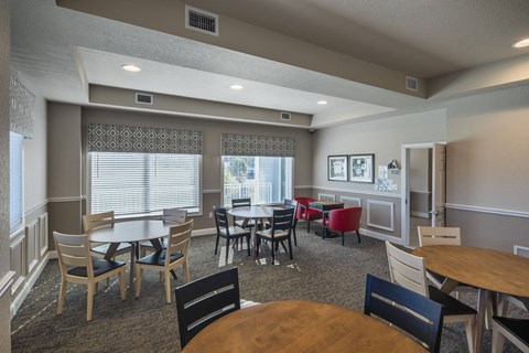 a dining room with tables and chairs and a kitchen