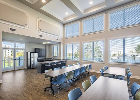 a large conference room with tables and chairs and a kitchen
