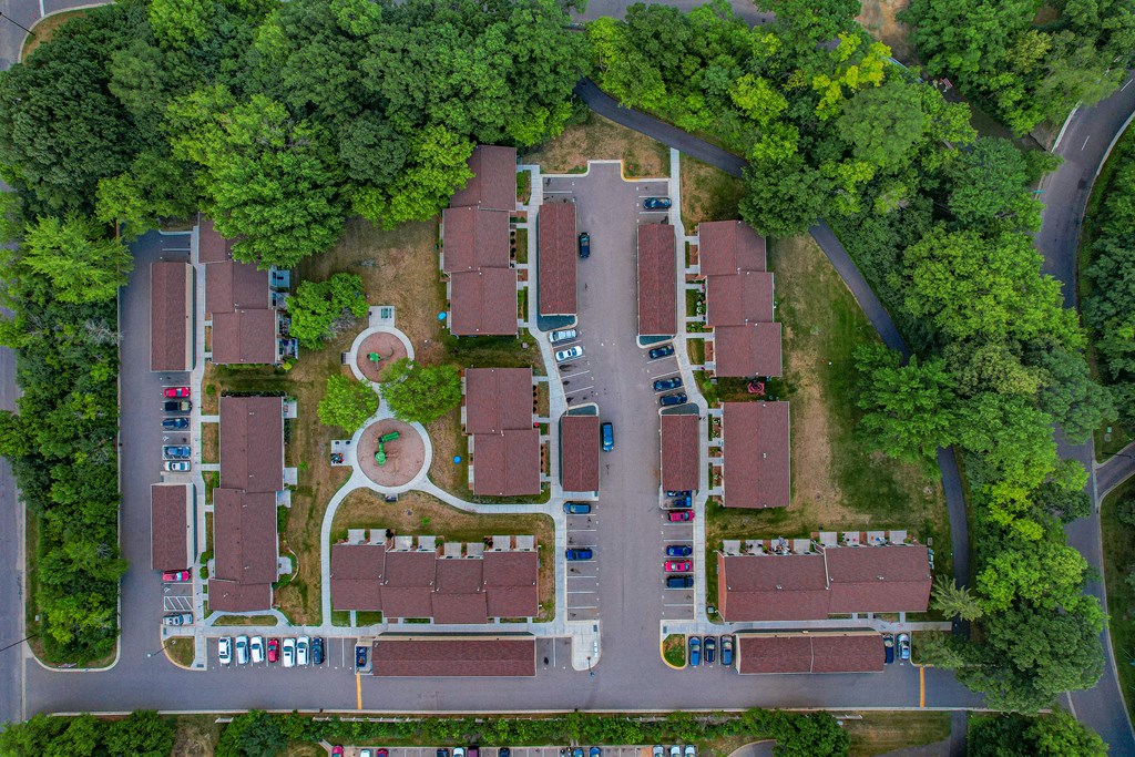 a birds eye view of a parking lot with buildings and trees