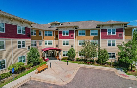 A large apartment complex with a red roof and a courtyard in the center.