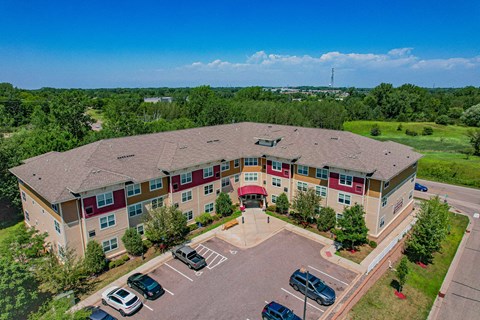 A large apartment complex with a parking lot in front.