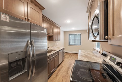 A modern kitchen with stainless steel appliances and wooden cabinets at Santa Vera Apartments.