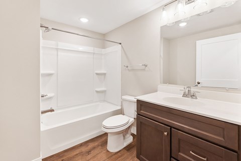 A white bathroom with a toilet, sink, and a tub and shower.