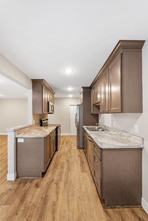 A kitchen with brown cabinets and a marble countertop at Santa Vera Apartments in Chanhassen, Minnesota..