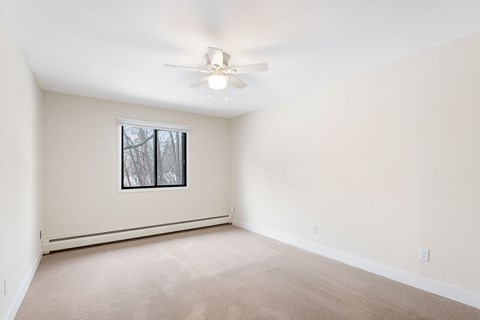 Bedroom with a ceiling fan and a window.