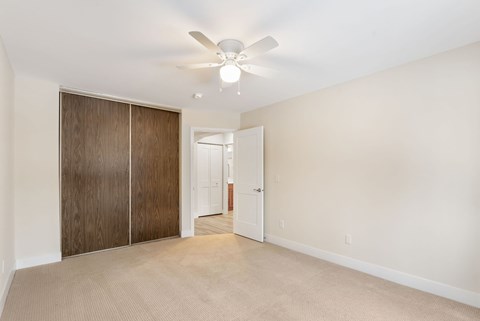 Bedroom with a ceiling fan and large closet at Santa Vera Apartments..