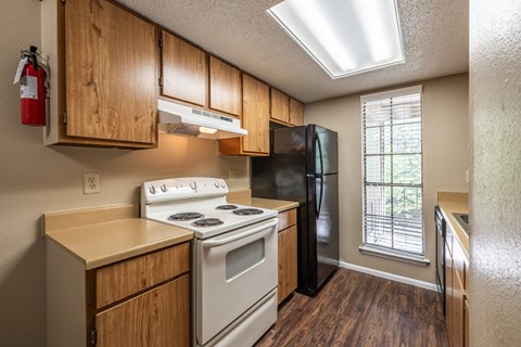 A kitchen with a white stove and black refrigerator.