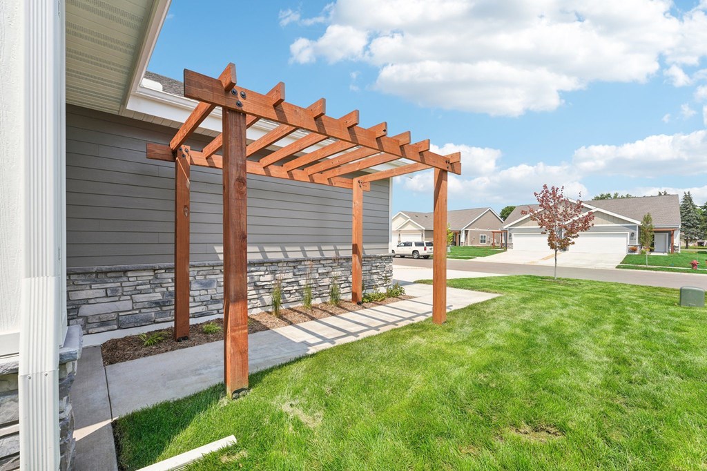 a wooden pergola at the entry to the twin home